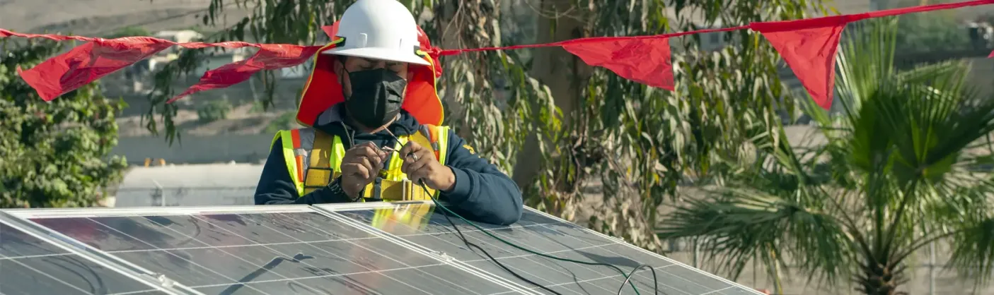 Solar panel installer working on wire connections