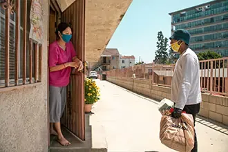 people distributing and receiving food during the COVID-19 pandemic