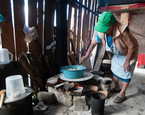 A woman cooks on an improvised stove in her kitchen in Mexico