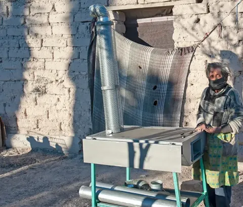 A woman poses for a portrait with her new stove in Mexico