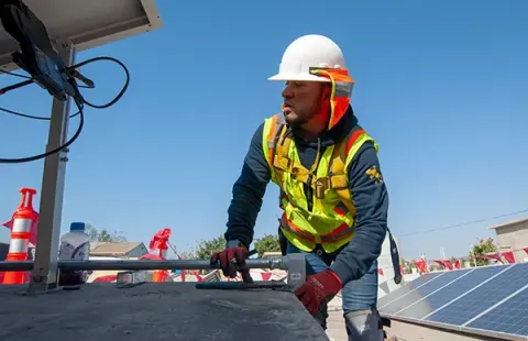A team member installs solar panels on a roof in Mexico