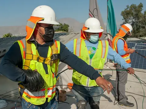 The team installs solar panels on a roof in Mexico