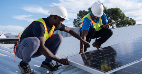 Two workers installing solar panels