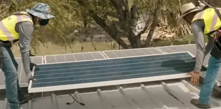 Team members install solar panels