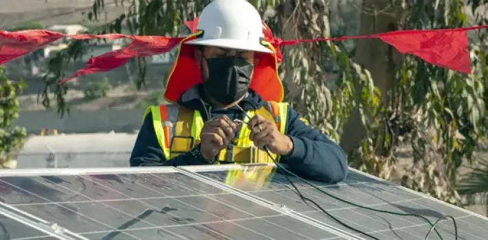 A team member installs solar panels on a roof in Mexico