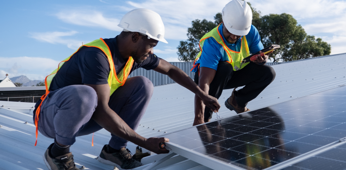 Two workers installing solar panels